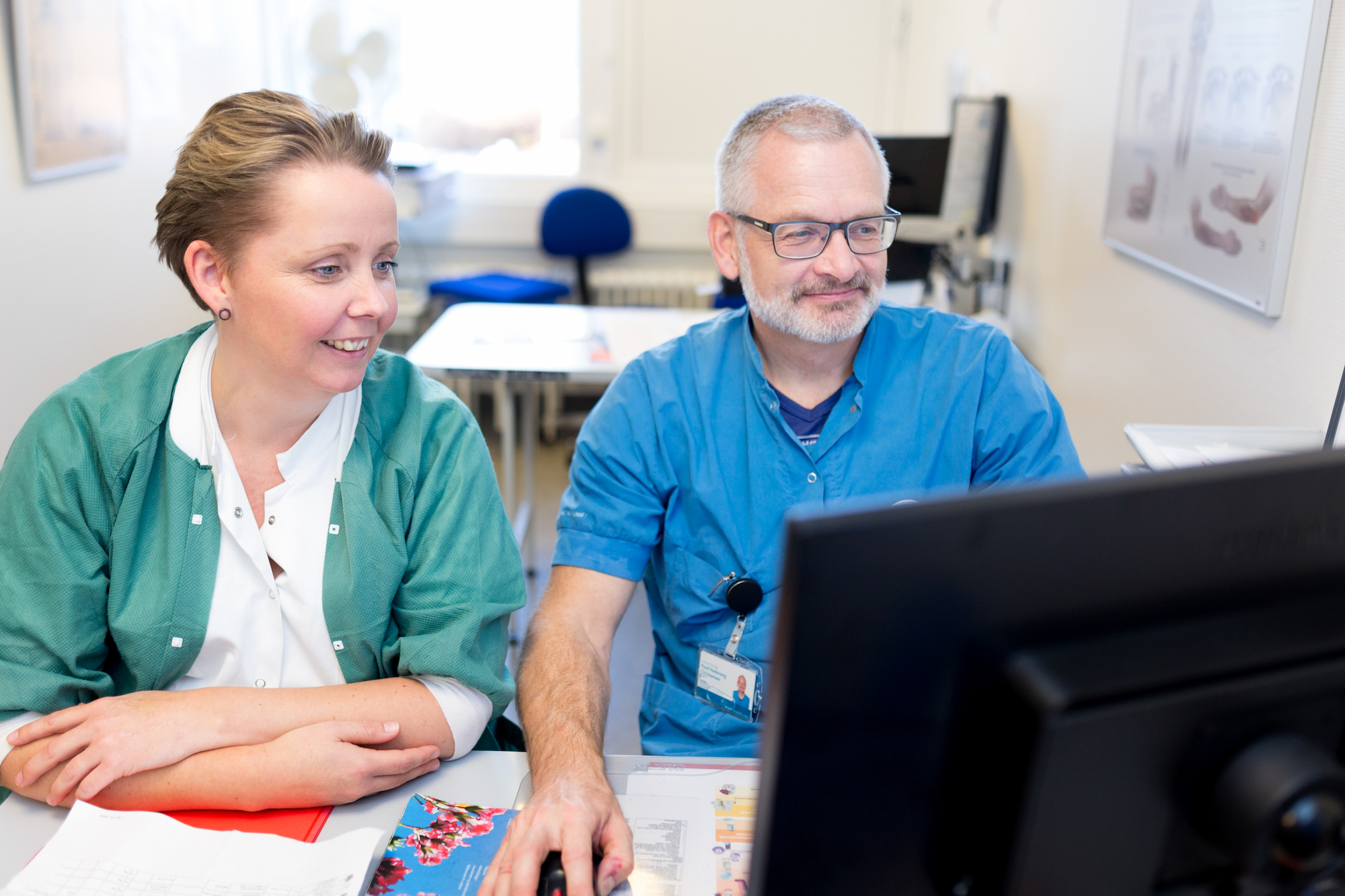 Kollegaer der sidder ved computer